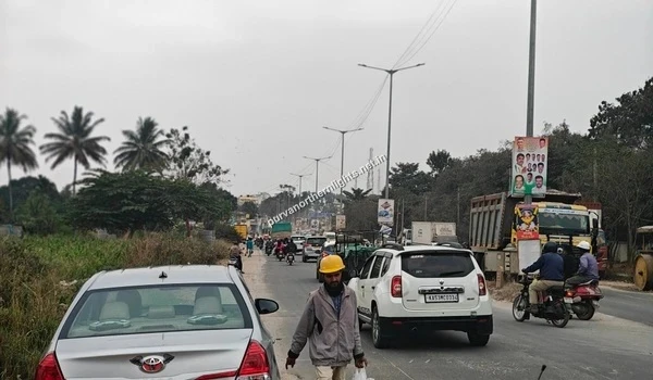 Busy street scene on Razak Palya road near Purva Northern Lights featuring traffic flow and local infrastructure