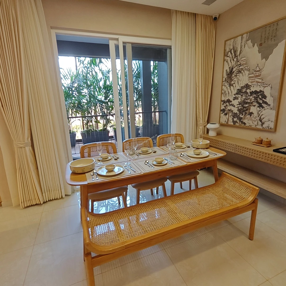 Close-up of the 6-seater dining arrangement at Purva Northern Lights featuring a wooden table and a traditional Japanese ink painting on the wall