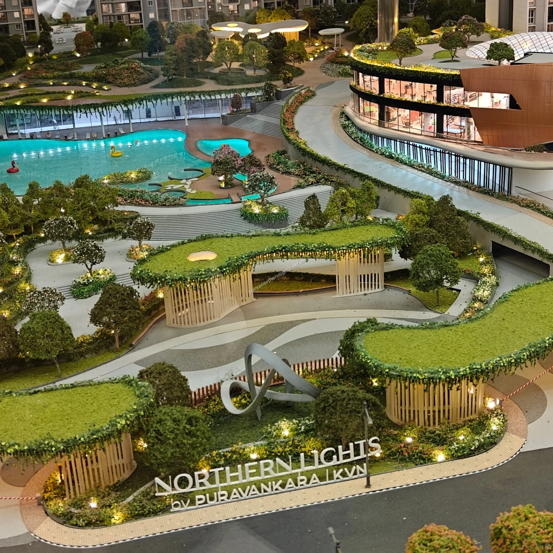 Close-up miniature view of the Purva Northern Lights entrance signage, decorative metal sculpture, and landscaped pergolas