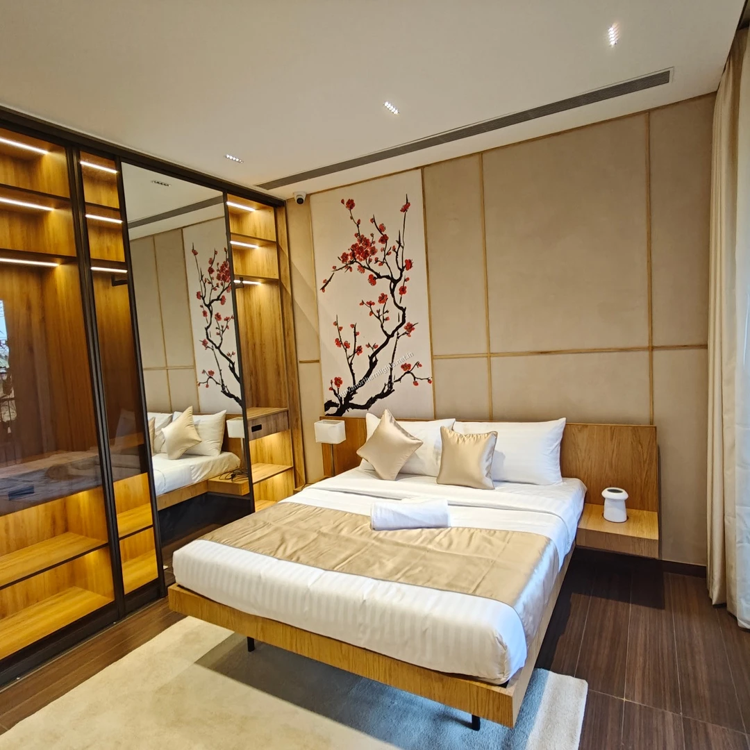 Full view of the master bedroom suite featuring a Japanese-inspired cherry blossom wall art, floating bed frame, and large mirrored wardrobes