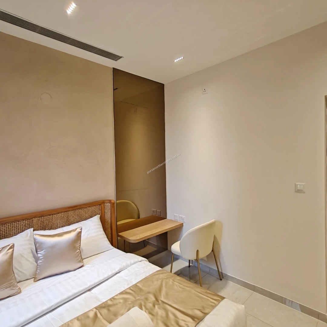 Elegant bedroom study corner featuring a floating wooden desk, minimalist white chair, and a full-length bronze-tinted mirror wall