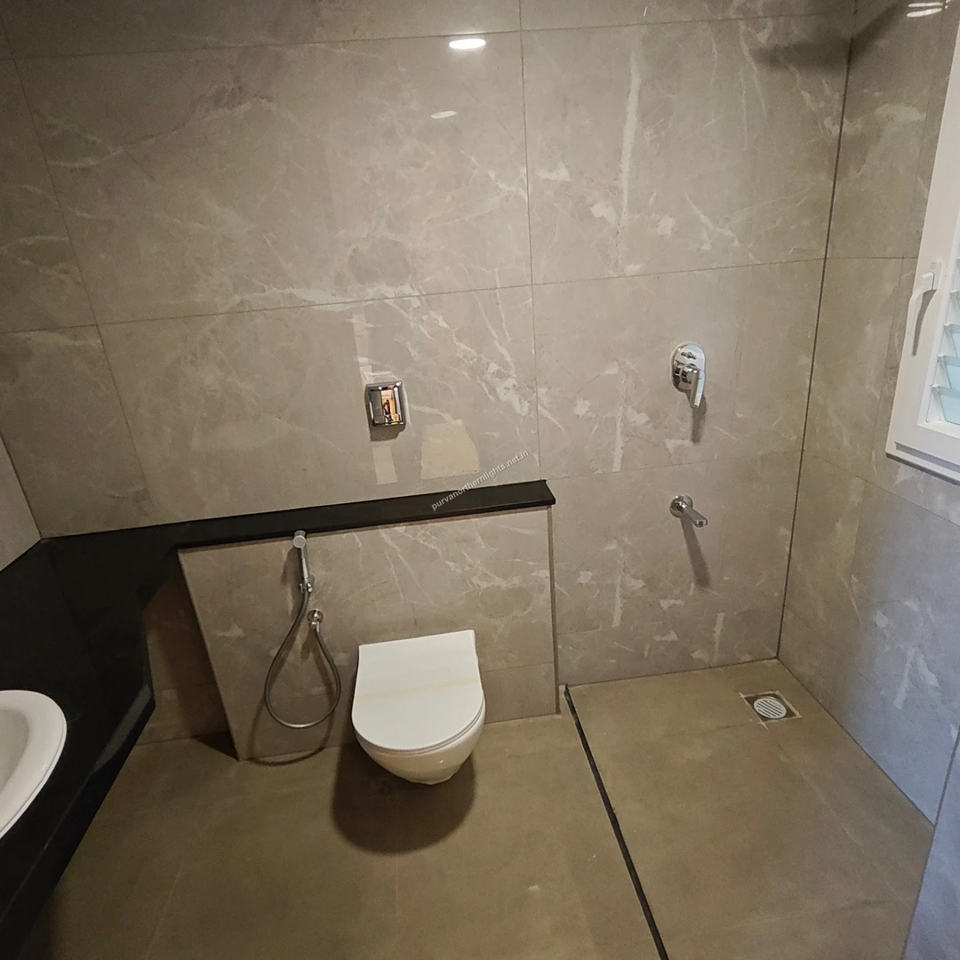 Modern bathroom at Purva Northern Lights with marble-finish wall tiles, premium sanitary ware, and a sleek glass shower partition