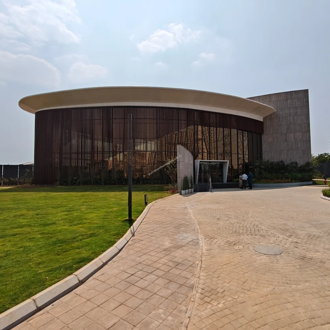 Full view of the striking circular architectural facade and paved driveway at the Purva Northern Lights office