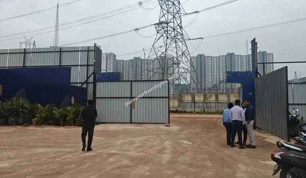 Detailed view of the Purva Northern Lights construction site entry gate with residential high-rise towers rising in the background