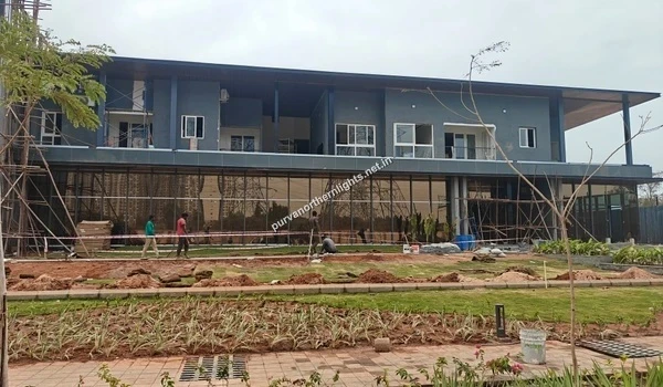 Exterior view of the Purva Northern Lights clubhouse showing glass facade and landscaping progress