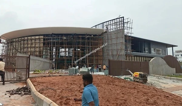 Construction progress view of the Purva Northern Lights KIADB Aerospace Park clubhouse building with scaffolding and workers