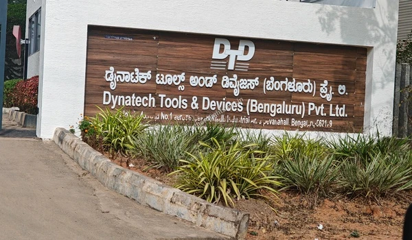 Front view of the Dynatech Tools & Devices (Bengaluru) Pvt. Ltd. company signage board with garden landscaping near Purva Northern Lights