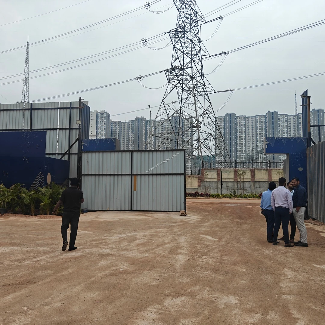 View of the main entrance to the temporary sales office at Purva Northern Lights showing gates and background towers