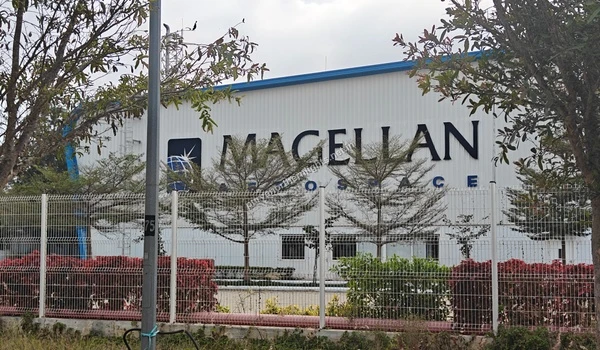Large white warehouse building of Magellan Aerospace with prominent black lettering on the facade near Purva Northern Lights