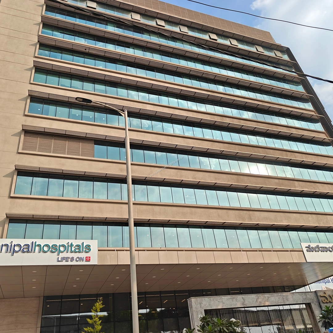 The impressive glass facade of Manipal Hospitals viewed on Mar 13, highlighting the extensive medical infrastructure near the community.