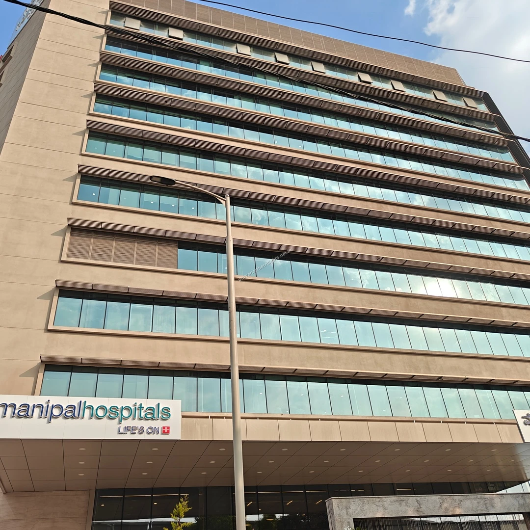 Looking up at the multi-story Manipal Hospitals building, a premier healthcare facility easily accessible from Purva Northern Lights.