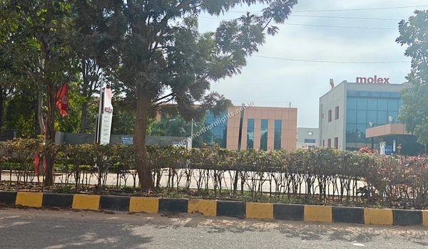 The landscaped entrance and glass facade of the Molex workplace as seen from the main road near Purva Northern Lights
