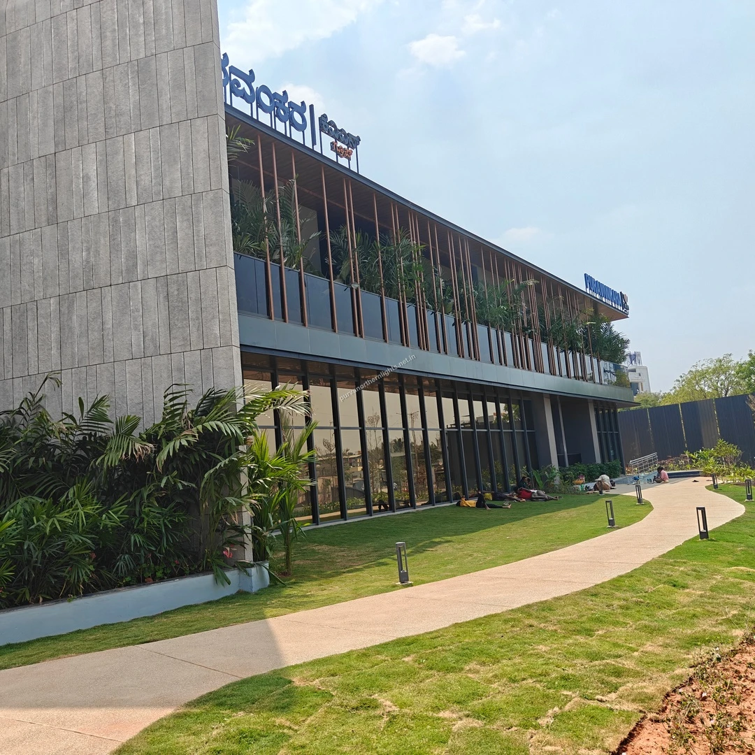 Modern architectural design of the Purva Northern Lights site office exterior featuring glass facades and green landscaping