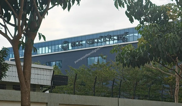 Exterior view of the RTX office building featuring the logo and Kannada text on the glass facade near Purva Northern Lights