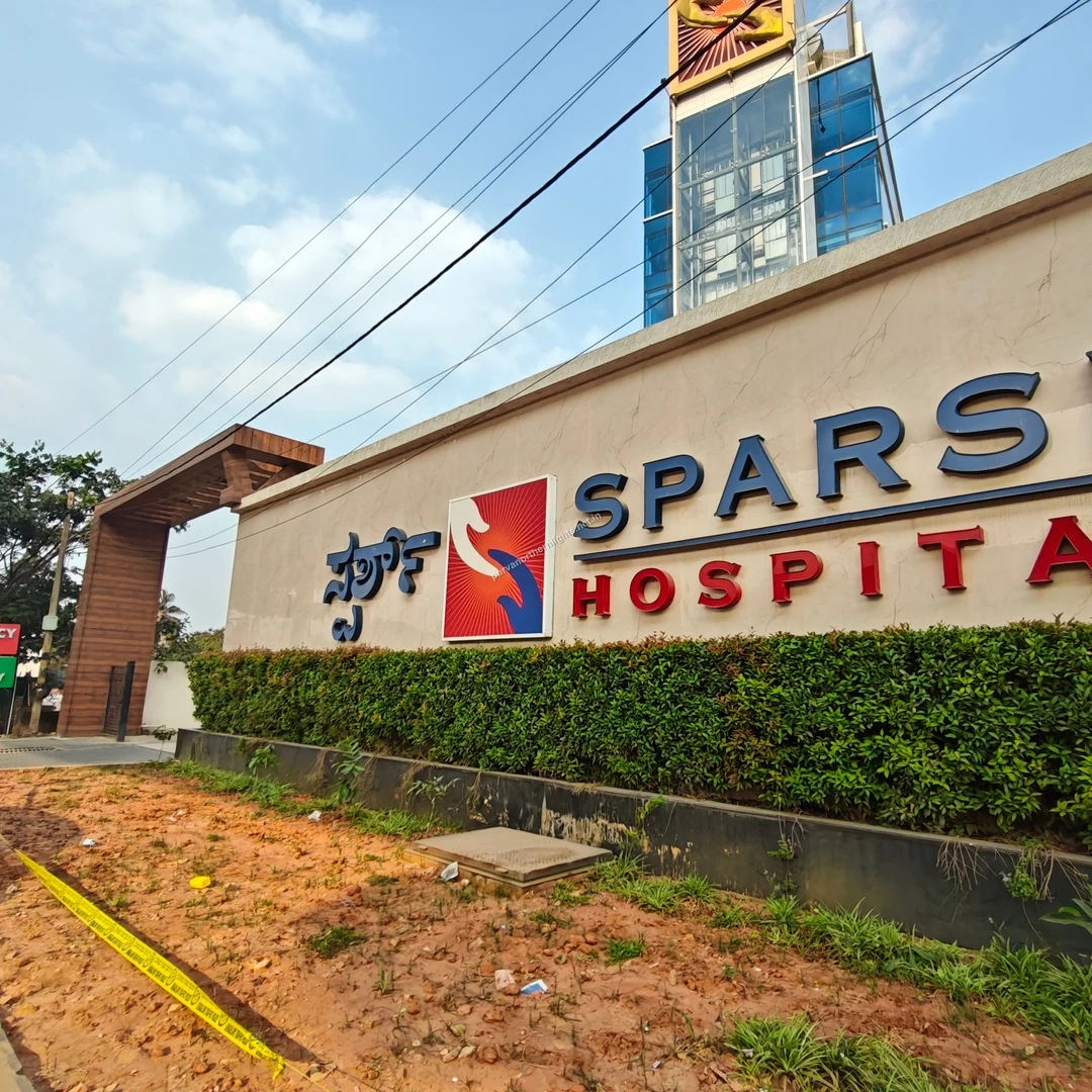 A bright Mar 13 morning view of the Sparsh Hospital exterior signage highlighting proximity to essential healthcare for nearby residents.