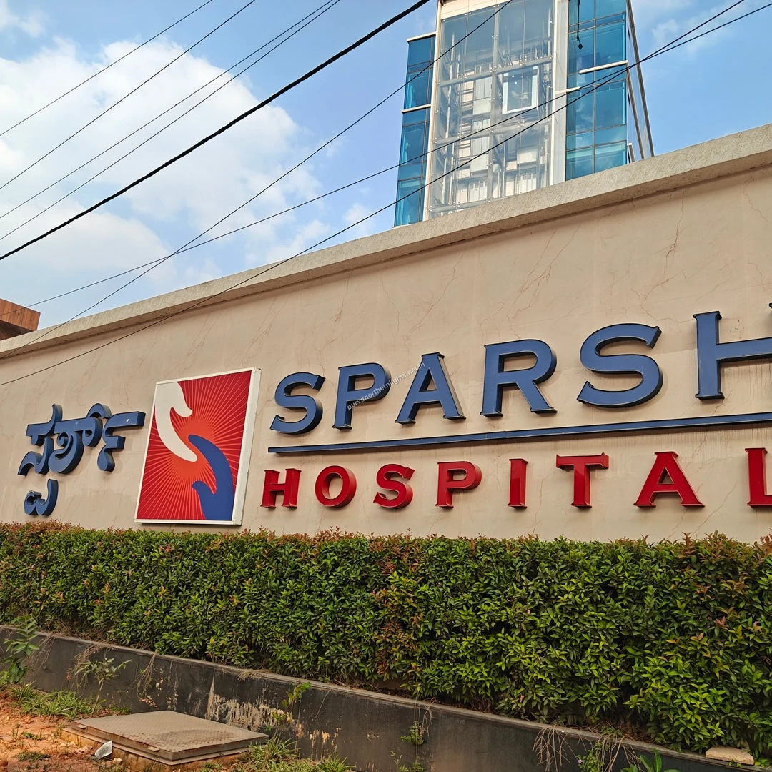 A clear Mar 13 view of the Sparsh Hospital sign, emphasizing the proximity of specialized medical treatments to the residential area.