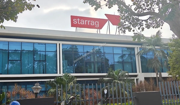 A wide view of the Starrag India corporate building featuring large glass windows, situated in the industrial neighborhood of Purva Northern Lights.