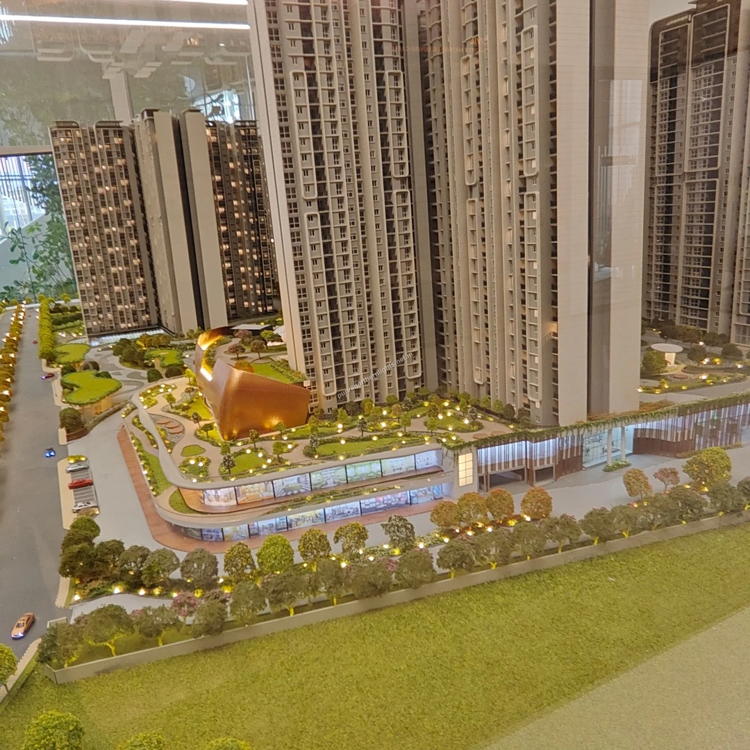 High-angle miniature model perspective showcasing the multi-level retail promenade and the glowing copper clubhouse at Purva Northern Lights on mar 13