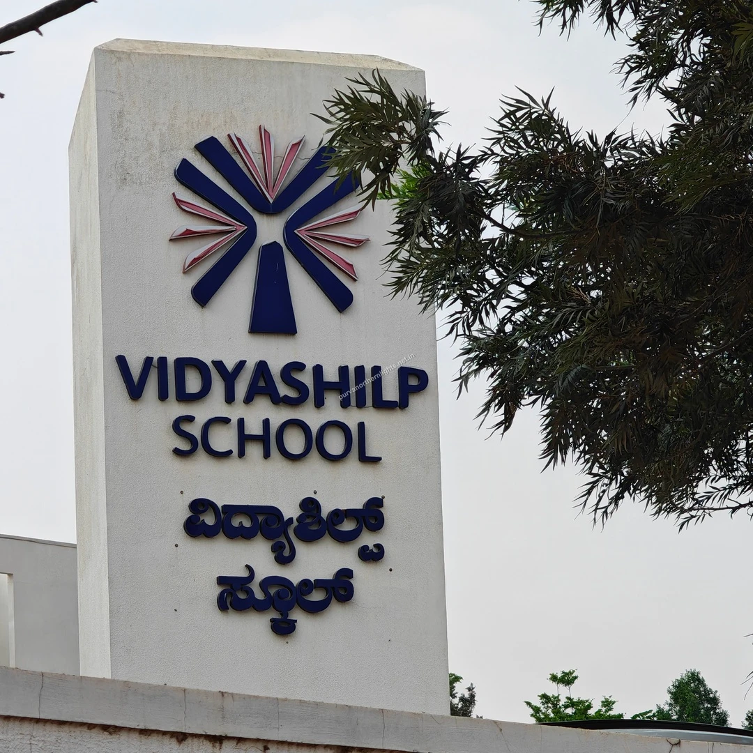 Vidyashilp Sign Board A close-up of the Vidyashilp School signage featuring its distinct blue and pink emblem, captured on a pleasant Mar 13.