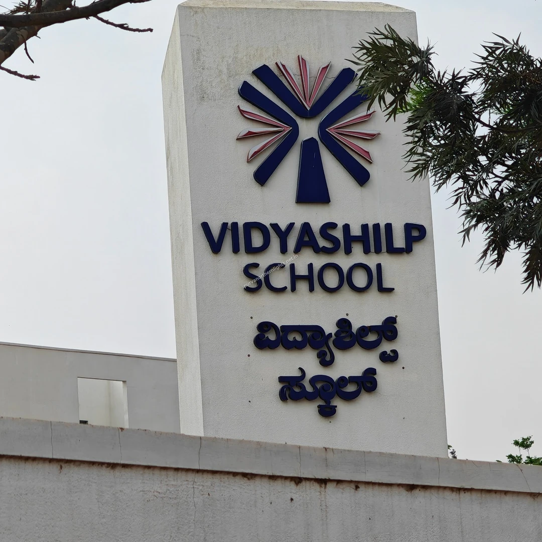 Vidyashilp Emblem View A detailed look at the blue and red starburst logo atop the Vidyashilp School entrance monument.
